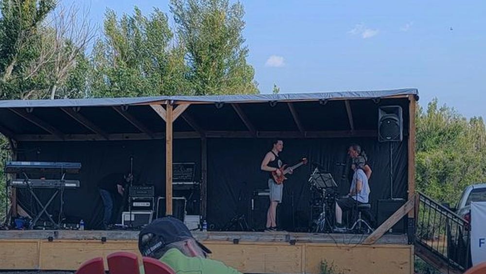 A band playing an outdoor summer concert on a community stage in Elizabeth, Colorado